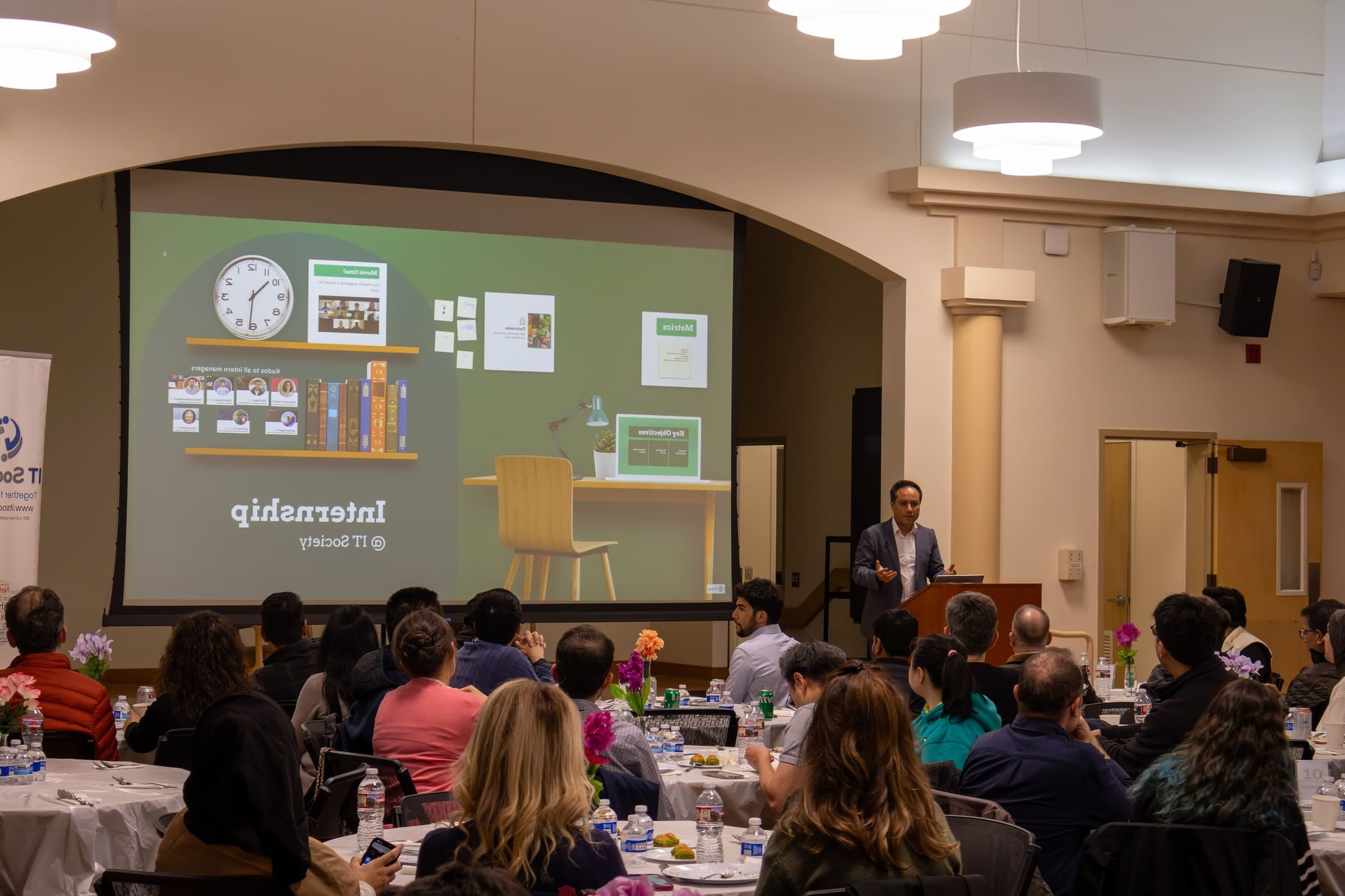 A speaker presenting on the IT Society internship program to a full room