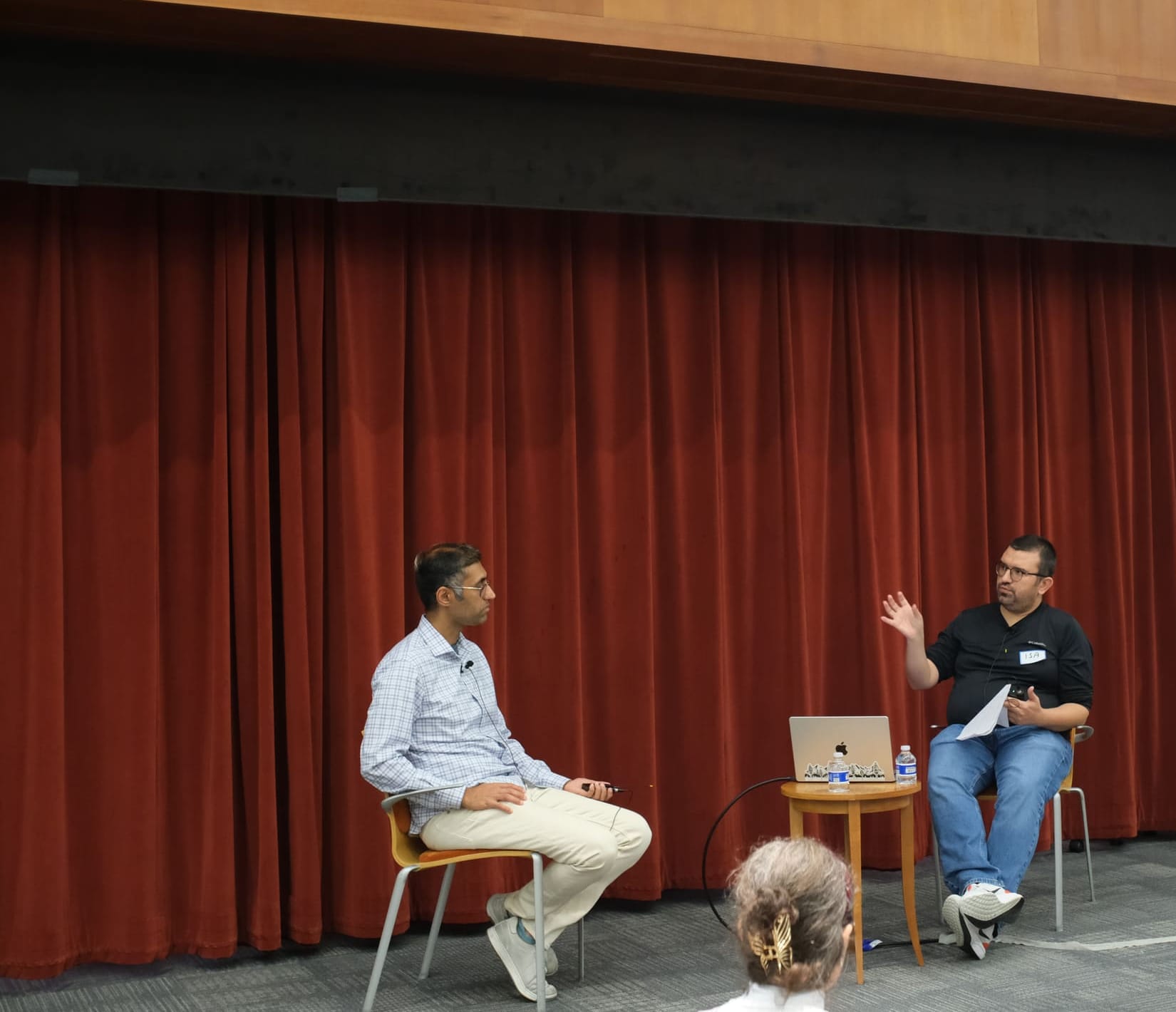 Two panelists in conversation on stage at an IT Society event